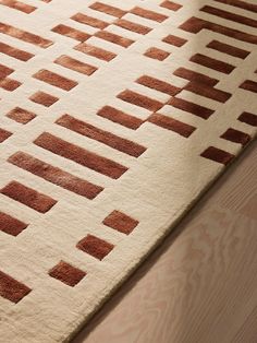 a brown and white rug on top of a wooden floor