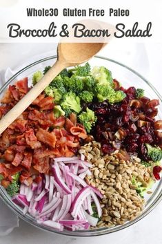 broccoli and bacon salad in a glass bowl with a wooden spoon on the side