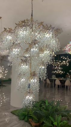 a large chandelier hanging from the ceiling in a room with tables and chairs