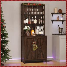 a wooden cabinet with wine glasses and christmas stockings hanging on the door, next to a decorated tree