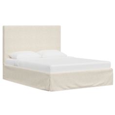 a bed with white sheets and pillows on it