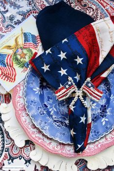 a patriotic place setting with red, white and blue napkins on top of it