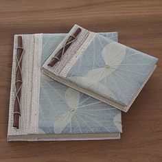 two napkins with leaves on them sitting on a table