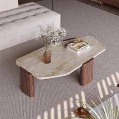 a living room with a couch, coffee table and books on the floor in front of it