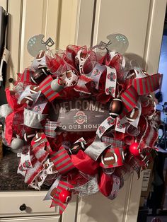 a red and silver football wreath with the words welcome to our home written on it