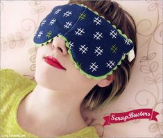 a woman laying on top of a bed wearing a sleep mask