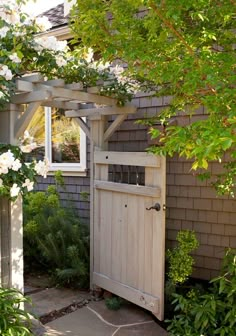 an outside view of a house with flowers on the door and in the yard area