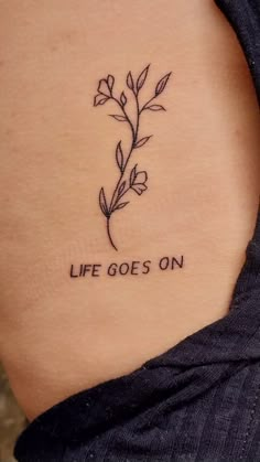 a woman's lower back tattoo with the words life goes on