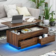 a living room with a couch, coffee table and laptop on top of the table