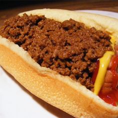 a chili cheese dog on a bun with ketchup and mustard