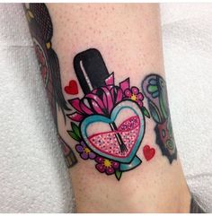 a woman's foot with a heart and flowers tattoo design on the left side of her leg