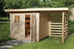 a wooden shed sitting on top of a lush green field