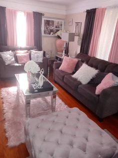 a living room filled with furniture and pink curtains