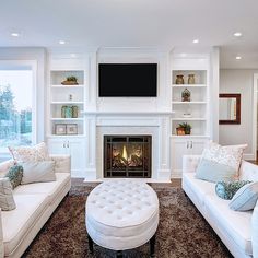 a living room with white furniture and a fireplace