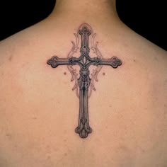 a cross tattoo on the back of a woman