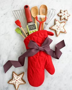 an oven mitt with utensils and cookies on it