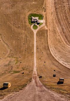 an aerial view of a farm with hay bales and a house in the middle