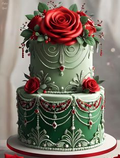 a three tiered cake decorated with red roses and beads on top of a table