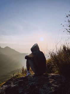 a person sitting on top of a mountain