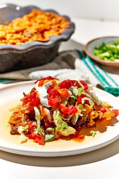 a white plate topped with food next to a casserole dish