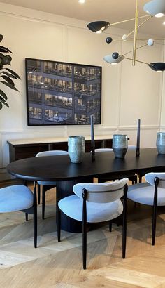 a dining room table with chairs and vases on it