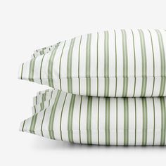 two green and white striped pillows on top of each other