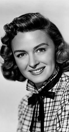 an old black and white photo of a woman wearing a plaid shirt with a tie