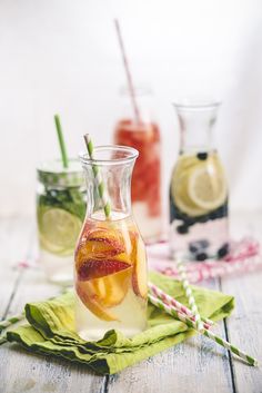 two pitchers filled with drinks sitting on top of a table