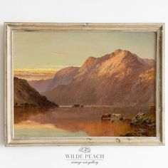 a painting hanging on the side of a wall next to a white framed object with an image of mountains in the background