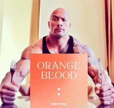 a man sitting at a table with an orange blood sign in front of his face