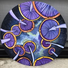 a plate with purple and orange designs on it sitting next to a window sill