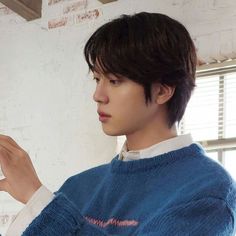 a young man in a blue sweater is holding something