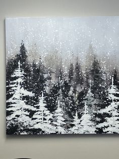 a black and white painting with trees in the background on a wall next to a chair