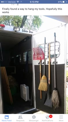 there are brooms, rakes and other items in the back of a trailer