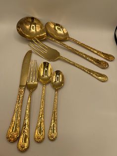 a group of gold colored utensils and spoons