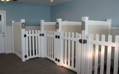 a room with white picket fenced in gates on the wall and carpeted floor