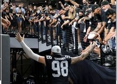 a group of people standing next to each other in front of a crowd at a football game