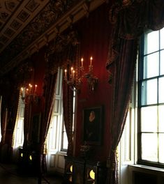 an ornate room with chandeliers and paintings on the walls, windows, and curtains