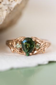 a green ring sitting on top of a piece of paper next to a rock and stone