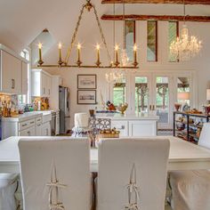 a dining room and kitchen area with white chairs