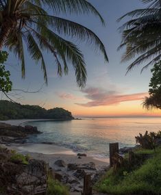 the sun is setting over the ocean and beach with steps leading to the water's edge