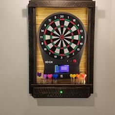 a dart board mounted to the side of a wall with darts in front of it