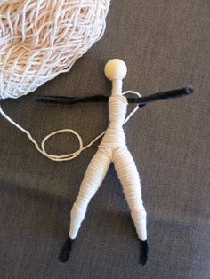 a string doll is next to a ball of yarn