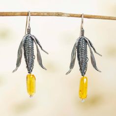 Sacred to every pre-Hispanic community in Mexico, today maize inspires Flora Maria in the elegant design of these earrings. Bright yellow amber resembles corn kernels that glisten with treasured elegance. Detailed with artistic realism, the sterling silver earrings are crafted with lost wax techniques featuring hollow backs and an antiqued finish. Natural amber is a fossilized resin, and no two pieces are alike in shape and color. Bits of moss and plant life may be seen within droplets of true a Amber Dangle Earrings In Baltic Amber, Traditional Amber Sterling Silver Jewelry, Elegant Amber Sterling Silver Earrings, Amber Dangle Earrings, Pierced, Amber Sterling Silver Dangle Earrings, Mexican Earrings, Dolphin Earrings, Natural Amber, Bird Earrings