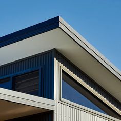 an airplane is flying over the top of a building with windows and roofing on it