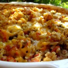 a casserole dish filled with rice and meat in a white bowl on top of a table