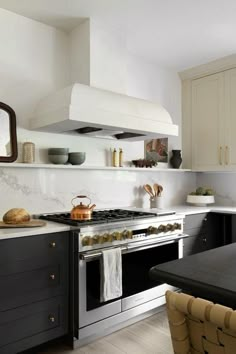 a stove top oven sitting inside of a kitchen next to a counter and chairs in front of it