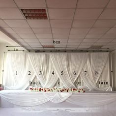 a room with white drapes and flowers on the wall, along with measurements for curtains