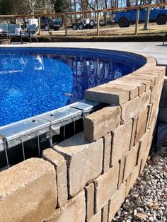 an empty swimming pool surrounded by rocks and gravel