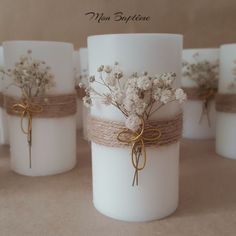 white candles with twine and flowers tied to them